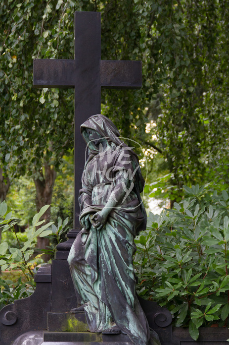 Trauernde an Grabkreuz