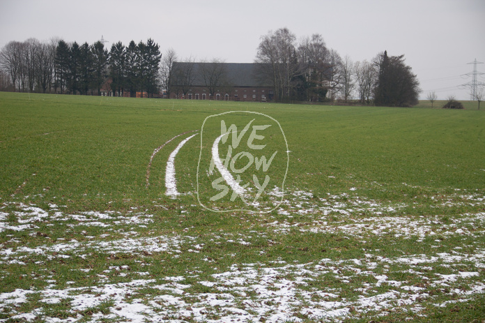 Schneespuren auf grünem Acker
