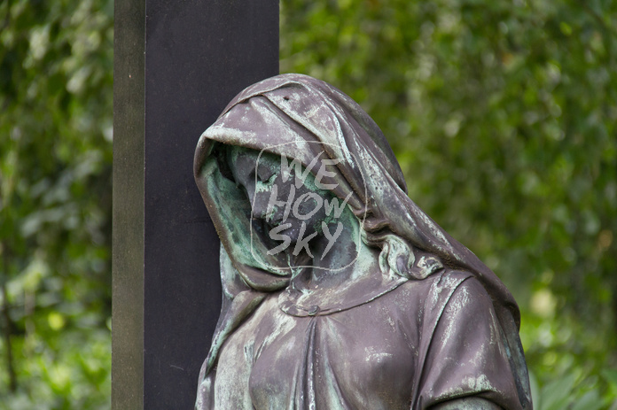Trauernde an Grabkreuz