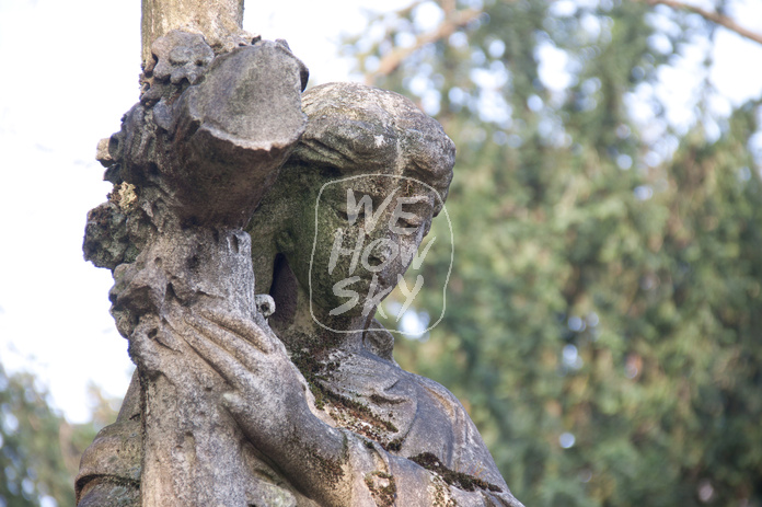 Frauenfigur trägt Kreuz