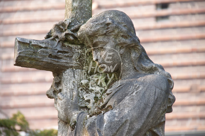 Frauenfigur trägt Kreuz