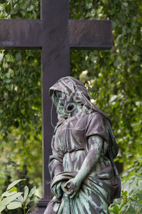 Trauernde an Grabkreuz