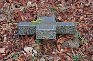 Grabkreuz im Laub