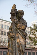 Frauenfigur trägt Kreuz
